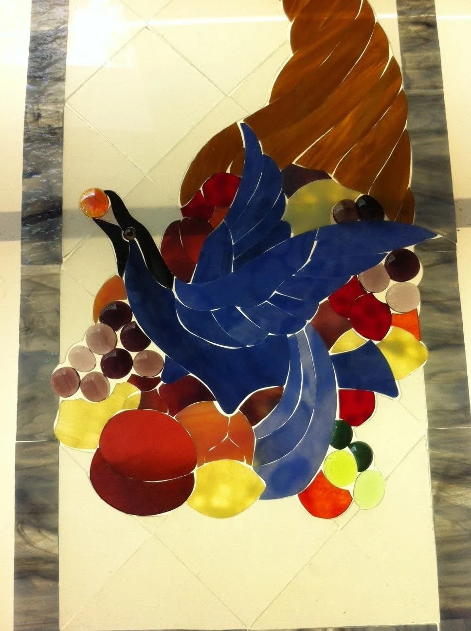 Blue bird and cornucopia glass held against the light