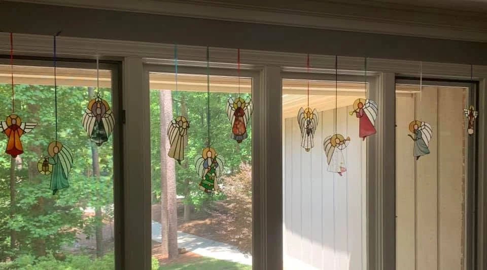Trish’s hanging angels displayed across sunlit windows