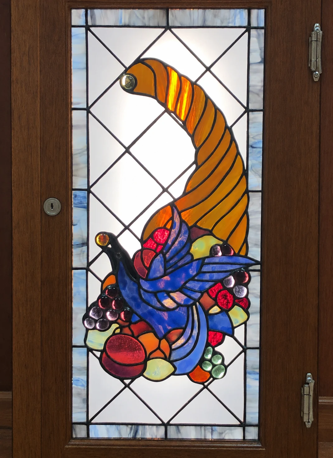 Blue bird & cornucopia panel installed in a wooden door